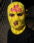 Yellow No Smiles ski mask, chain-link fence